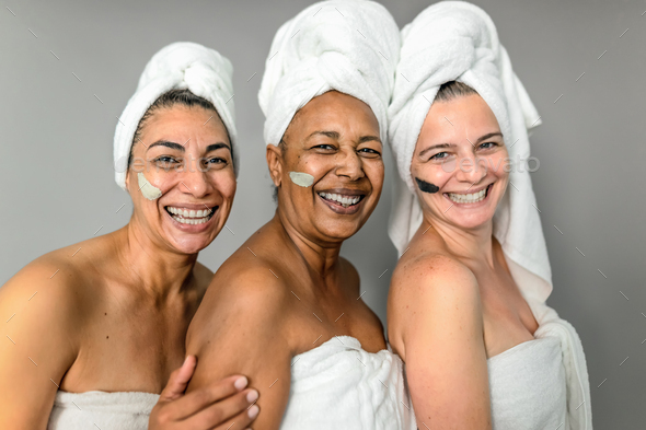 Happy multiracial senior women having skin care spa day - People wellness lifestyle concept