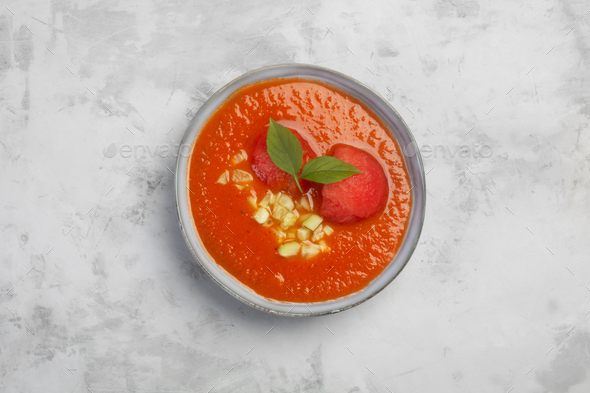 Traditional Spanish dish gazpacho. Cold gazpacho in a plate on a gray background