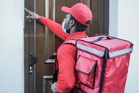 African man working for food delivery with thermal backpack while wearing surgical face mask