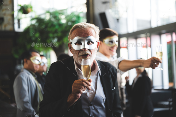 business team party, businessman and businesswomen wearing fancy mask