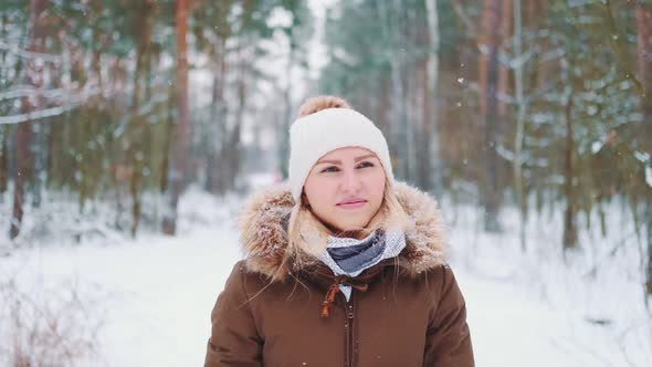 Pretty Woman in Winter Walking and Admiring the Snowy Forest