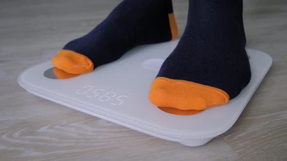 Close Up Male Feet in Sock Stepping on Floor Scales  Man Weighing Himself