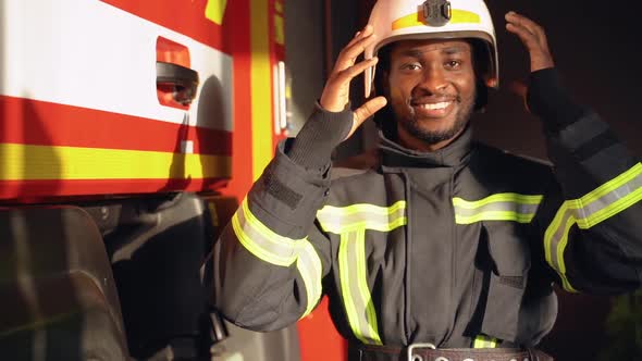 Black Fire Fighter Preparing for Emergency Call at the Station alt