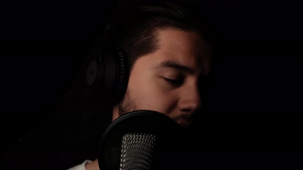 Man Sings Into Microphone Records His Song in Recording Studio Professional Singer Dark Room with