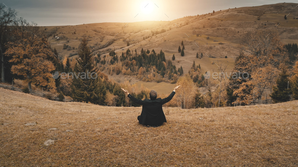 Business man rise-up hands at sun mountain aerial. Rural recreation at countryside nature landscape - Stock Photo - Images