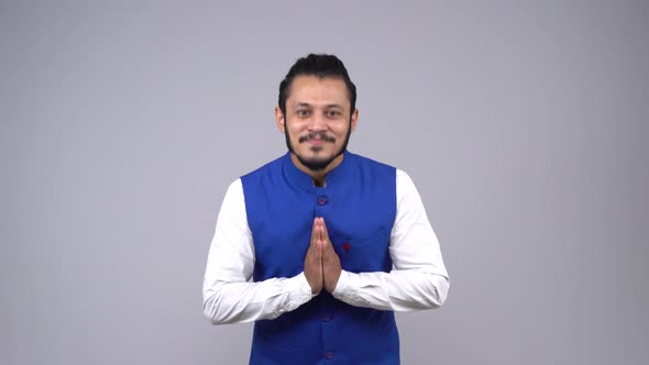 Indian man doing Namaste in Indian traditional wear alt