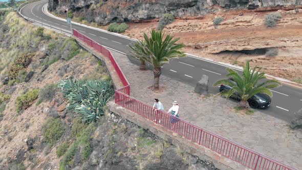 Aerial View of Two People Standing on the Edge of a Cliff on an Island in the Atlantic Ocean
