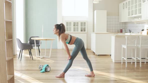 Sporty Young Woman Is Making Lunge in Yoga Pose in Stretching Legs at Home. alt