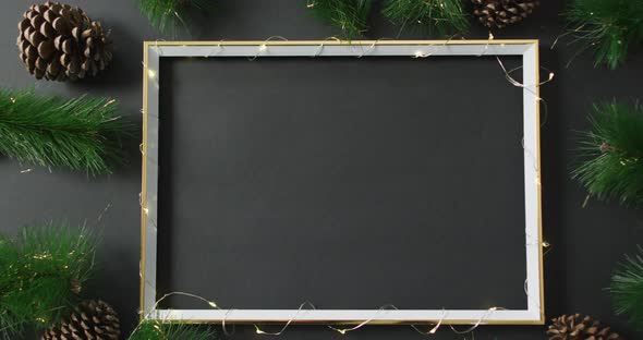 Video of christmas decorations with string lights around frame and copy space on black background alt