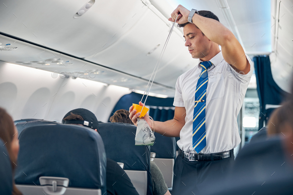 Man with oxygen mask demonstrating safety procedure prior to passenger airplane flight