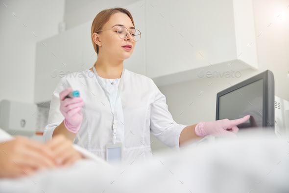 Doctor adjusting the treatment parameters on the touch screen - Stock Photo - Images