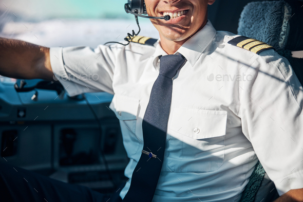 Happy young pilot at workplace in jet