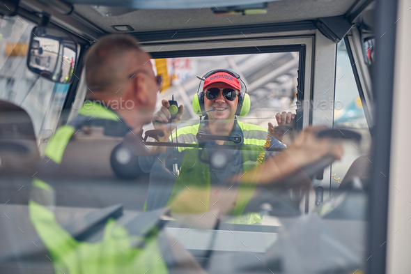 Smiling aircraft supervisor talking to a truck driver