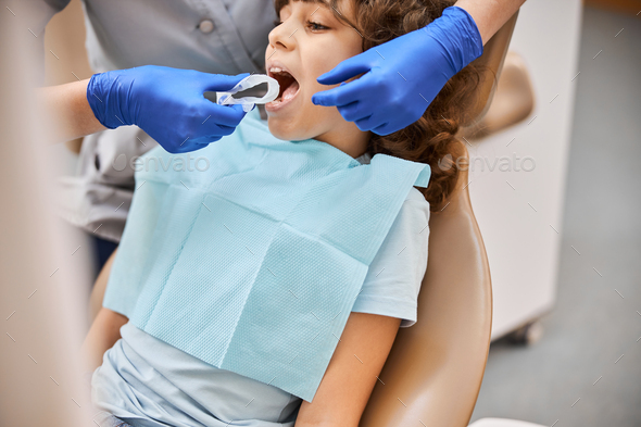 Dentist using a disposable dental rubber dam