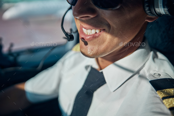 Smiling young male pilot enjoying his work in skies