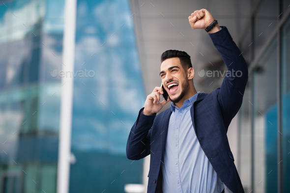 Ecstatic businessman having phone conversation with business partner, copy space