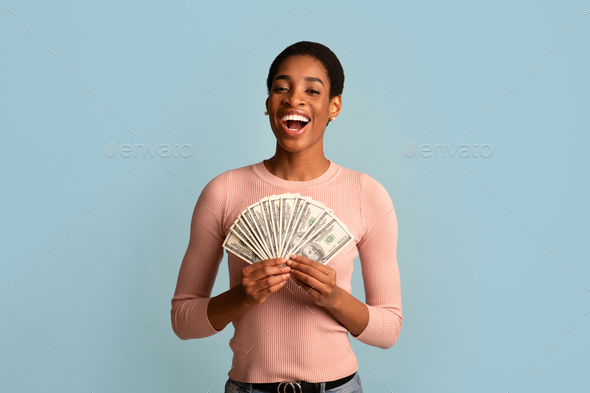 Cash Bonus. Joyful Black Female Holding Fan Of Dollar Banknotes In Hands