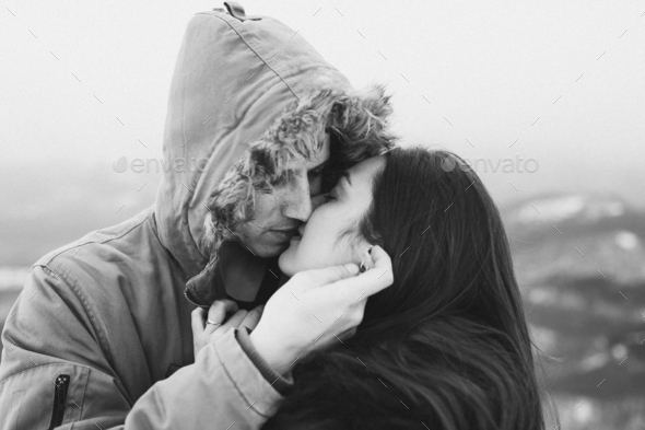 Teenager couple kissing hooded. Winter casual style, parka with fur hood