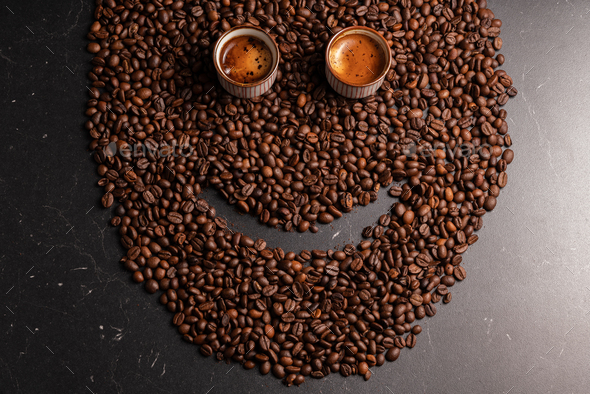 Laughing face made from coffee beans, eyes made from coffee and hair made from ground coffee