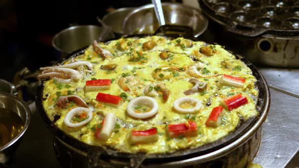 Traditional seafood omelet on an flat grill street food market, Bangkok alt