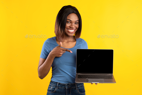 African American Woman Showing Laptop Empty Screen Over Yellow ...