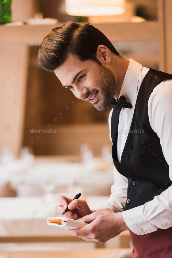 smiling waiter writing down the order