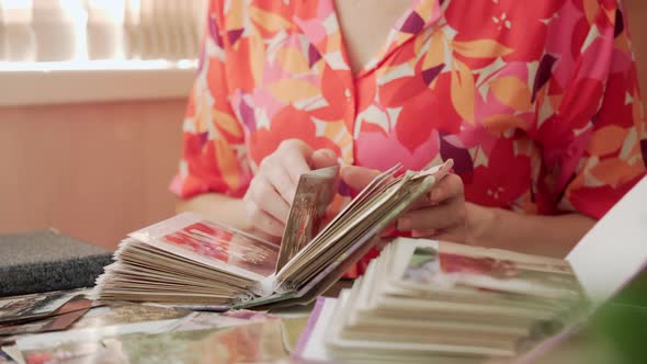Women's Hands Flipping Through Pages of Old Photo Album