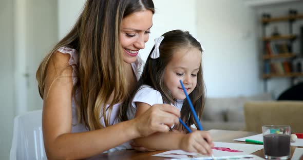 Little Girl Painting with Her Mother at Home
