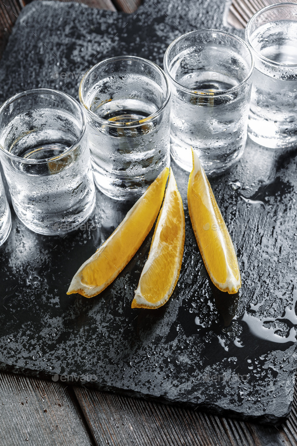 Vodka in shot glasses on rustic wood background Stock Photo by FabrikaPhoto