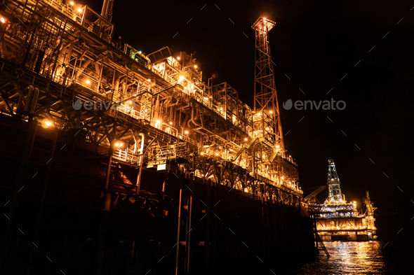 FPSO tanker vessel near Oil platform Rig at night. Offshore oil and gas industry