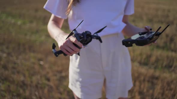 A Woman Checks the Drone and Remote Controller Before Launching the Quadcopter. Smart Wireless