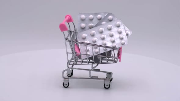 Packaging of tablets in a small shopping cart on a white background