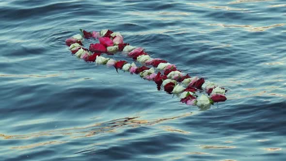 Memory concept. A wreath of flowers floating in the water.