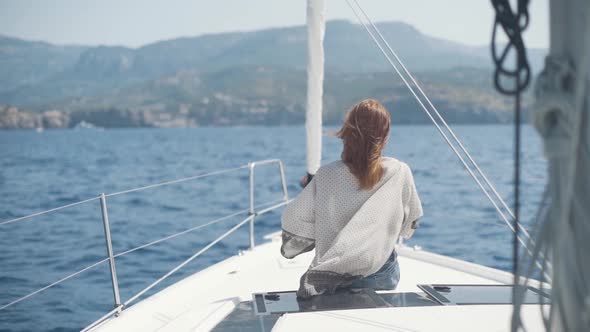 Beautiful Woman on a Yacht Enjoys the Journey on the Background of the Islands of Ibiza or Mallorca alt