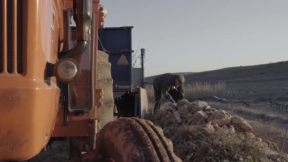 Old man with rough rock in hand alt