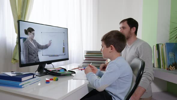 Children Learning Online, Parent Helps His Son Learn Lessons Uses Modern Technology for Distance alt