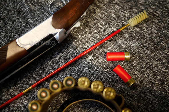 Hunting rifle, bandolier and ramrod in gun store - Stock Photo - Images