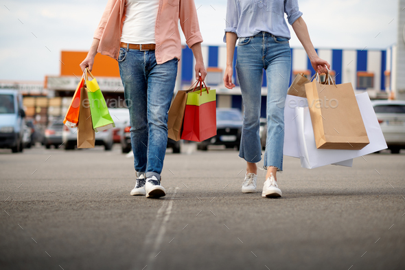 Man and woman with bags on supermarket car parking - Stock Photo - Images