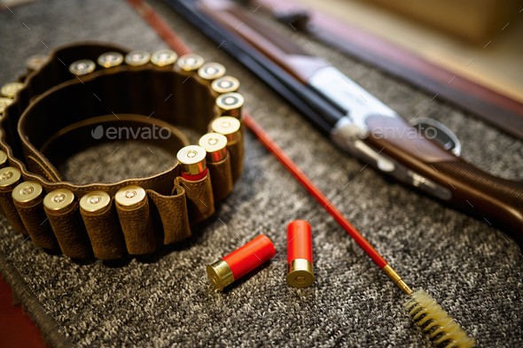 Hunting rifle, bandolier and ramrod in gun store - Stock Photo - Images