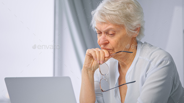 Corporate lady manager pensioner takes glasses off relaxing from work