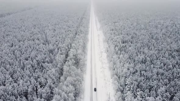 Aerial Top View From Drone Birds Eye View of Winter Landscape and Snowy Ice Road Car Moving on Area