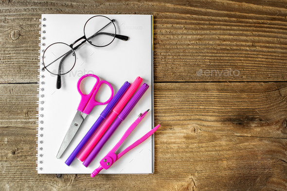 Pink scissors, notepad and markers. The concept of school, creativity, childhood.