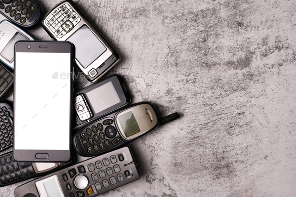 A smartphone on pile of obsoleted cellphones with a grunge background.
