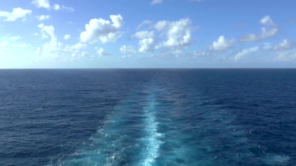 Cruise ship trails in open sea.