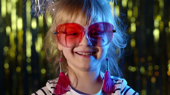 Portrait of Trendy Stylish Girl Looking at Camera Smiling Child Kid in Neon Light at Disco Club alt