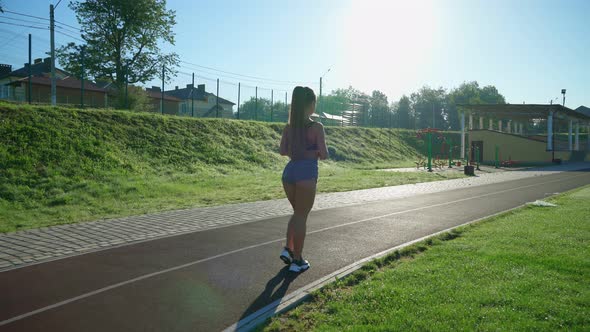 Girl Walking Doing Lunges at Stadium alt