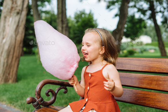 Cute Girl Eating Cotton Candy Stock Photo by Kaloriya | PhotoDune