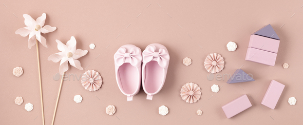 Cute newborn baby girl shoes with festive decoration over pink background.  Baby shower, birthday Stock Photo by OksaLy