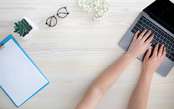 Top view of female hands typing on laptop keyboard, sitting at table, free space - Stock Photo - Images