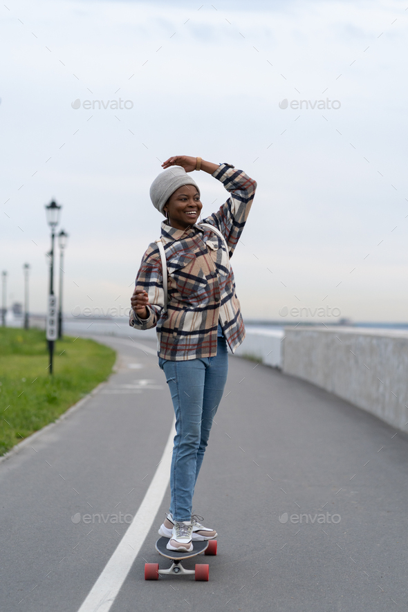 Zaailing Onderbreking Bekentenis Happy african girl on longboard, cheerful female skate enjoy fresh air and  extreme active lifestyle Stock Photo by varyapigu